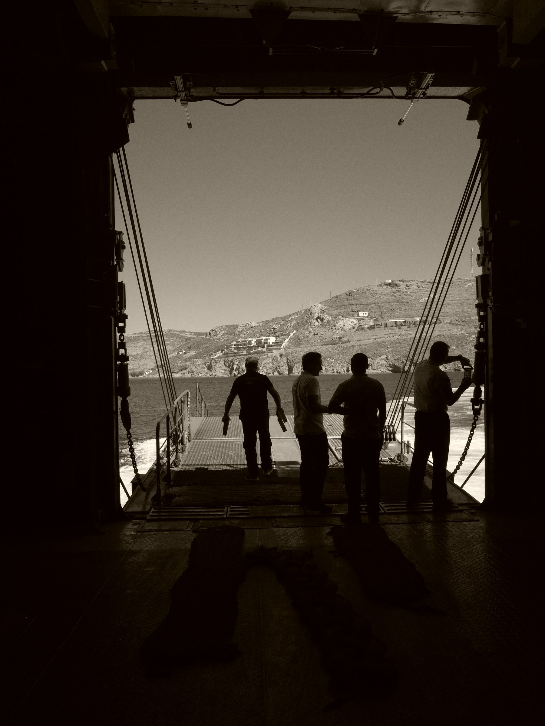 Silhouettes crossing a bridge in sepia tones
