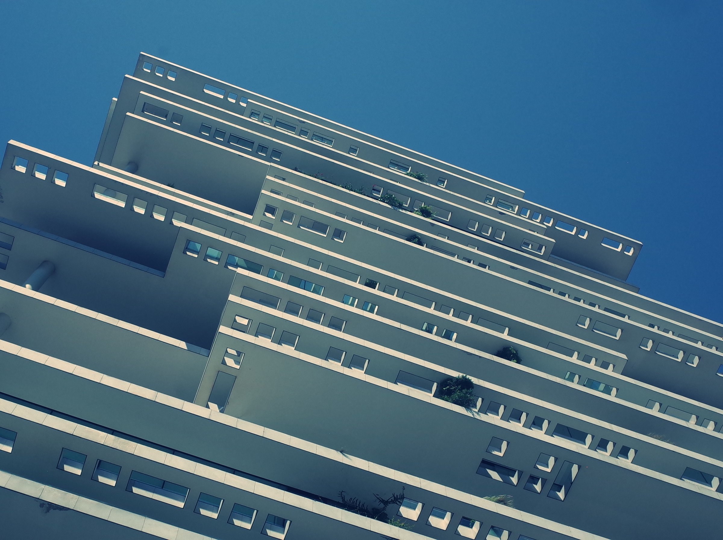 Modernist white residential tower against blue sky