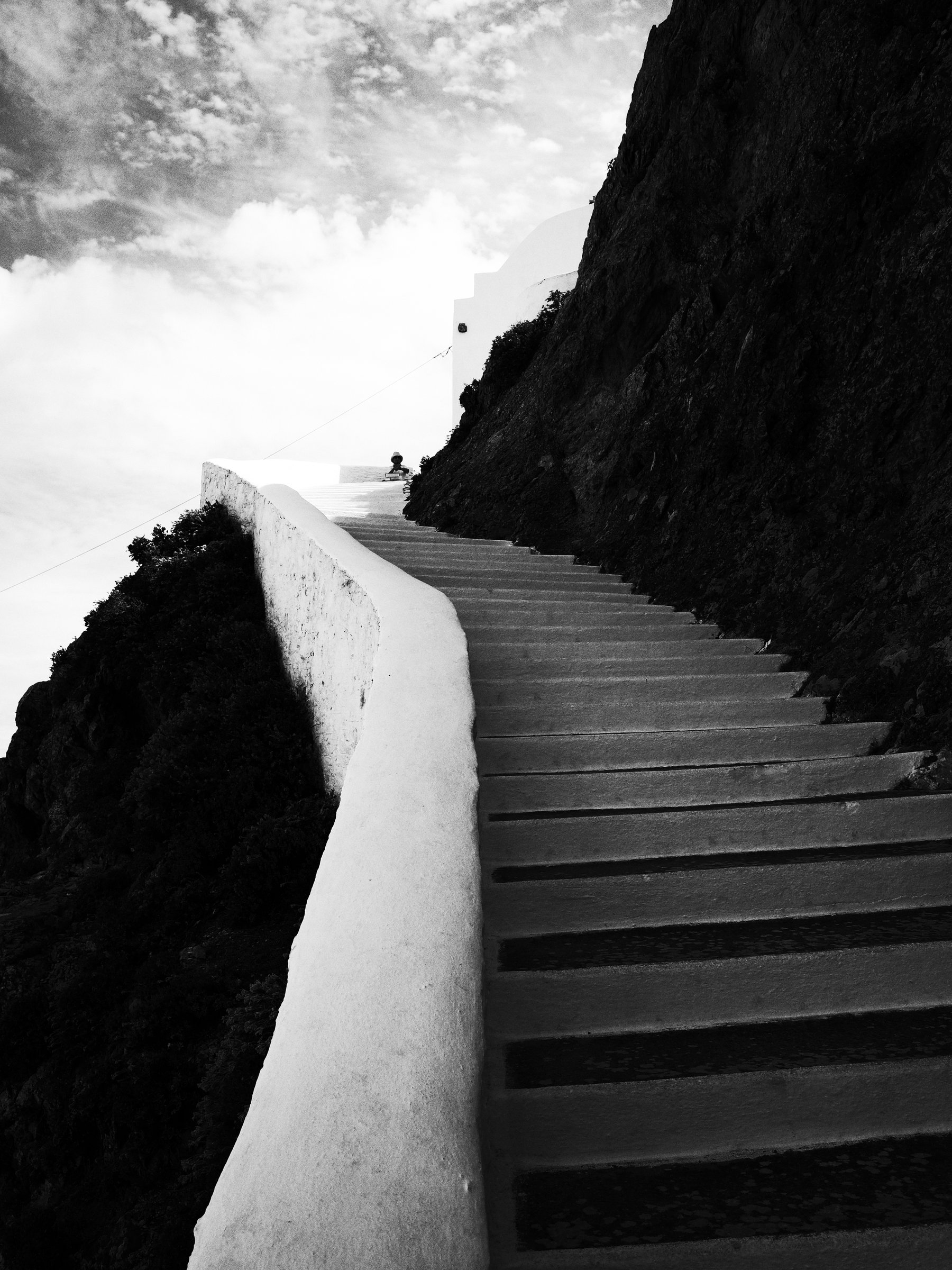 White Cycladic staircase descending toward the sea