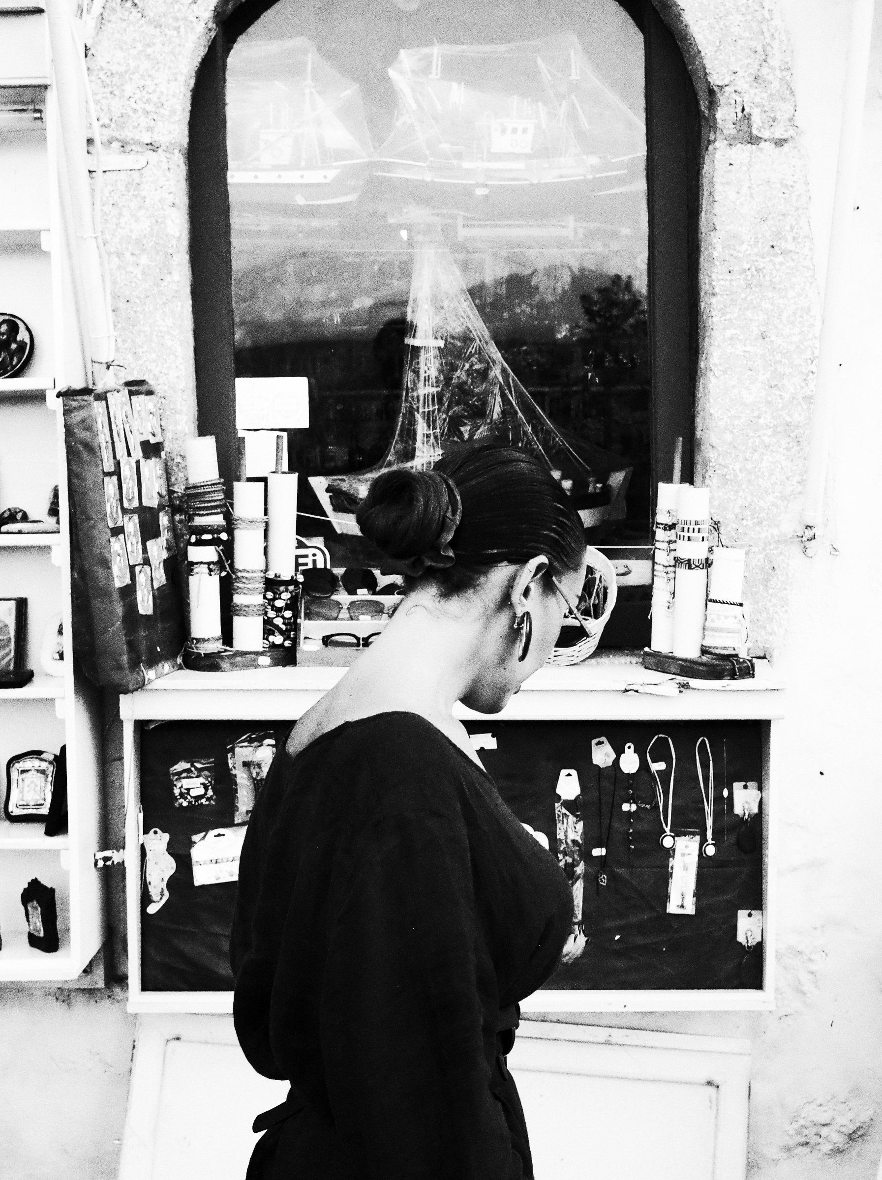 Black and white documentary, hand reaching into a jewellery display