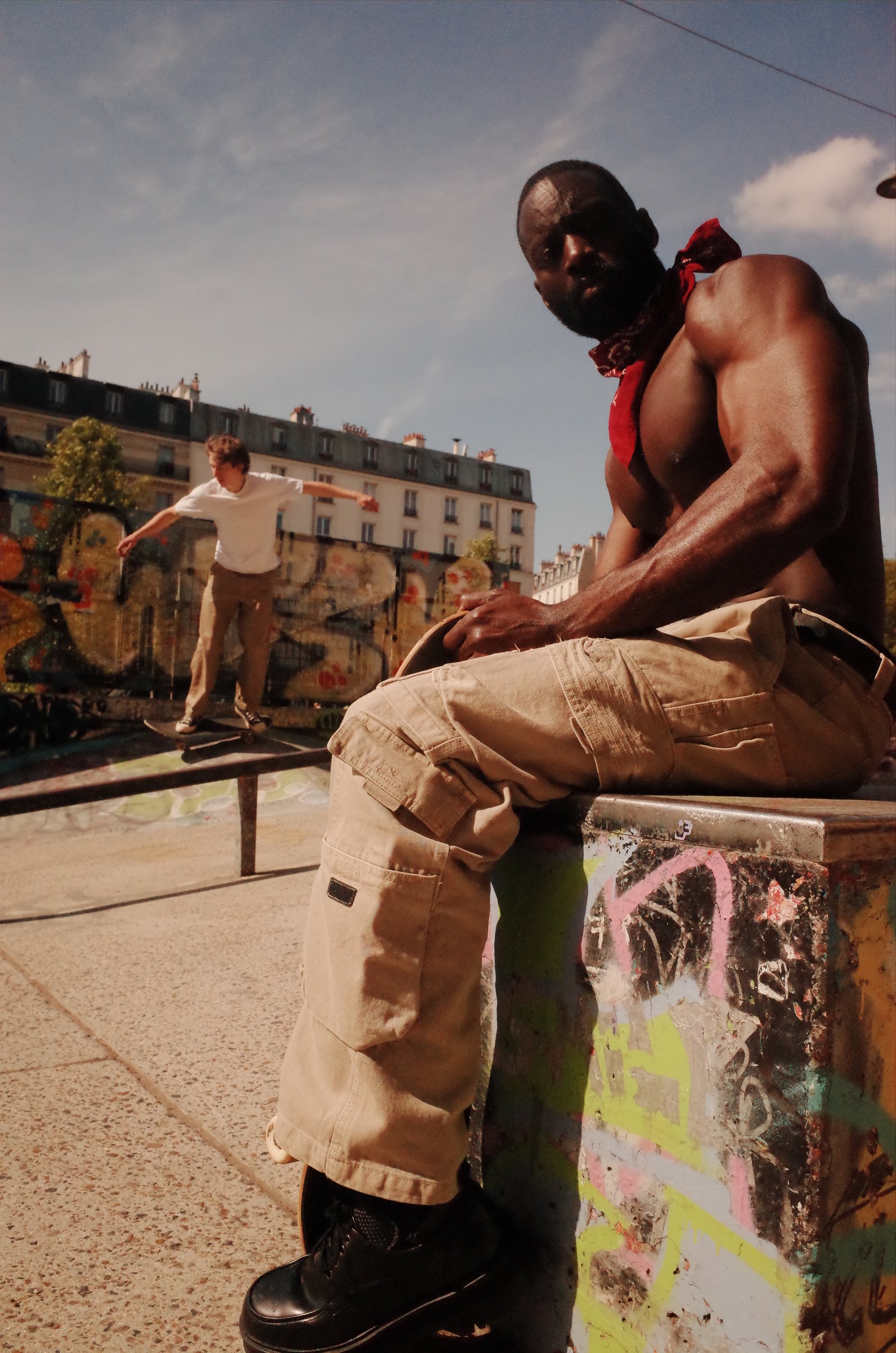 Street fashion, figure resting on dumpster, summer light